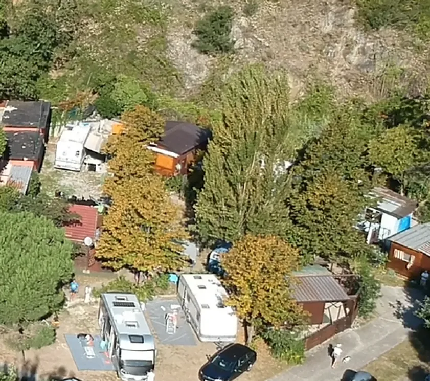 Vista aerea di un campeggio immerso nella natura con caravan e bungalow.