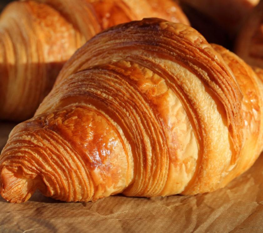 Un croissant dorato e croccante su carta da forno.
