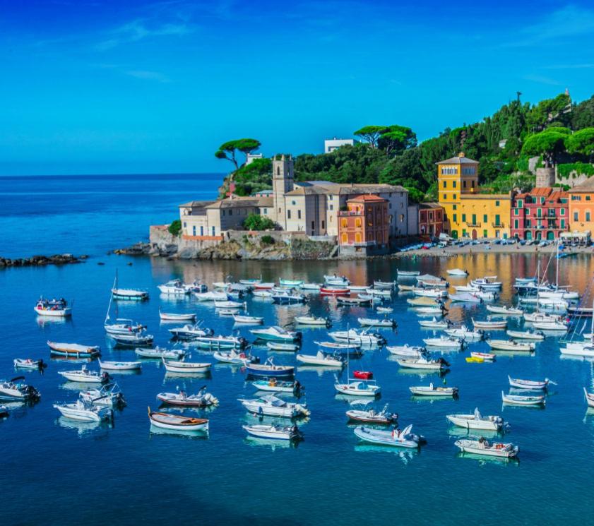 Affascinante baia con barche, edifici colorati e paesaggio verdeggiante.